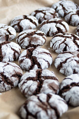 Delicious sweet brownie chocolate chip cookies sprinkled with powdered sugar on craft paper. Homemade baking. Close up.