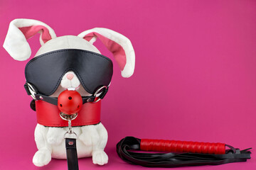 A toy rabbit dressed in BDSM accessories. BDSM toys. The concept of a sex shop