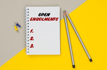 On a yellow-gray background are pencils, buttons and a notebook in which it is written - OPEN...