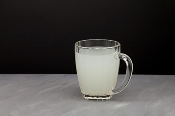 Homemade ginger Kombucha or milk-white kvass in a large glass mug. Healthy fermented drink. Dark background, copy space