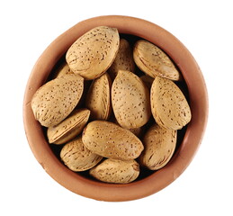 Almond nuts in shells, kernels in clay pot isolated on white background, top view