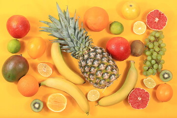 Detox diet and weight loss concept. summer tropical fruits and vegetables on yellow table, top view, healthy and natural food, source of vitamin C, banner for shop, selective focus,