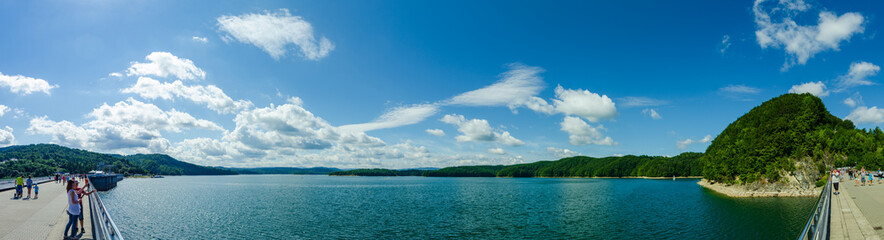 Summer day at dam in Poland. People walking over the dam.
