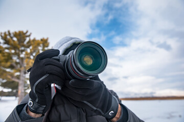 Fototapeta premium man holding camera in snowy nature