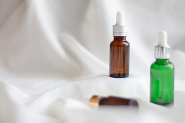Natural facial essential oil or serum packaging on white fabric background. Beauty product branding mock-up. Cosmetic skincare concept. Minimal and luxury. light and shadow. copy space for text.