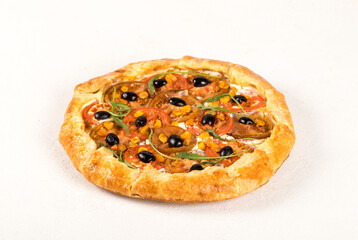 Open hot pie with red and black tomatoes, olives, arugula and ricotta on a light background 