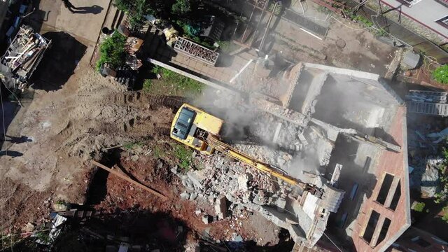 Camera rises turning above demolition site at village block