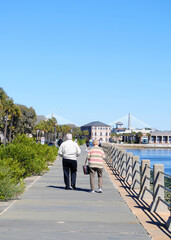 Fototapeta na wymiar Older couple walking along the water