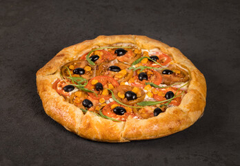 Open hot pie with red and black tomatoes, olives, arugula and ricotta on a dark gray background