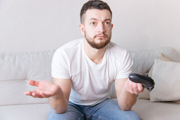 Angry man playing video games at home. People emotions lifestyle concept. Play game with joystick spreading hands.