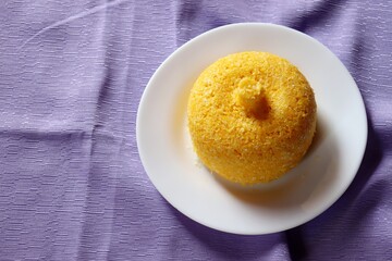 Brazilian Couscous on purple background. Corn couscous. 