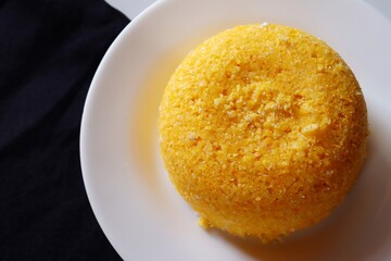 Brazilian Couscous on black background, with place for text. Typical food from the Northeast region of Brazil. Corn food.