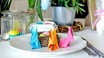 Easter creative table setting.Colorful Easter bunny made of origami paper