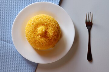Cuscuz Brasileiro em fundo azul. Comida típica do Nordeste do Brasil. Cuscuz de milho. 