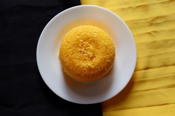 Brazilian Couscous on black and yellow background, with place for text. Corn couscous. Brazilian food. 