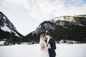 Naklejka premium Kissing wedding couple staying over beautiful landscape