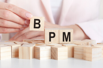 The word BPM on a wooden toy blocks with womans hands