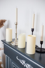 Fototapeta premium Candles of various types and sizes with and without candlesticks on fireplace