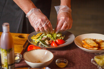 Chef makes a delicious caesar salad. Close-up. Hands in the frame.