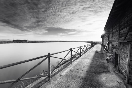 Wooden shed for salt storage, pre-industrial saltern, near the mouth of the Mondego river, on a summer sunrise, Black and White Photo, Figueira da Foz, Portugal