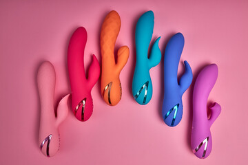 Bright Colorful G-spot Vibrators Arranged On Pink Paper Background, Big Variety Of Dildo Colours. Copy Space, Flat Lay