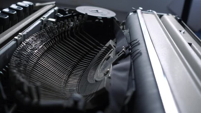 Macro shot on typebars of a mechanical typewriter. Concept of old technologies, type, and print for news and documents. Nostalgic idea. An author working on an old retro typewriter.