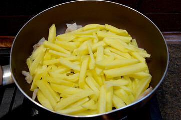 the raw potato sticks are laid out in the pan, at the end of cooking there will be fried potatoes