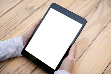 hand holding tablet pc on wooden table
