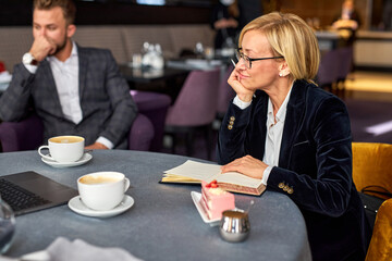 two thoughtful business partners sit together, thinking about business ideas and steps for successful work