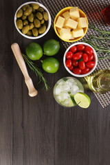 Caipirinha, a typical Brazilian cocktail made with lemon, cachaça and sugar. Tomato, cheese and olives. Selective focus