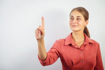 Woman touching an imaginary screen with her finger.Portrait of female college student touching...