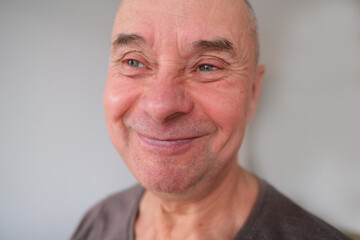 face of European old man close up, wrinkles on aging skin, smiling, good mood concept, cosmetology, age-related changes