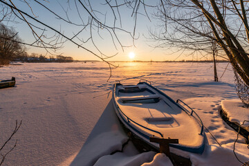 boat on the bank of a frozen river
