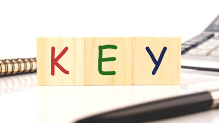 word key on wooden blocks next to pen, calculator, notepad on white background