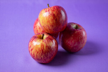 bright red apples on lilac background