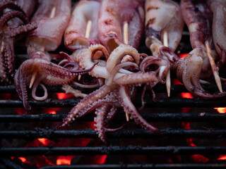 Fresh marinaded squid roasting on the grill