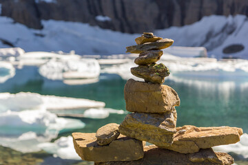 Cairn in front of a mountain lake with icebergs, Montana