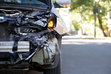 Destroyed car in car crash traffic accident on city road with copy space. Smashed broken front auto...