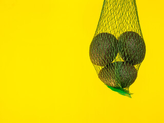 Avocados in a green net isolated and suspended on air
 horizontal 