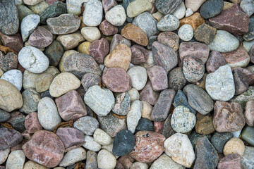 An isolated image of smooth colourful river rocks.