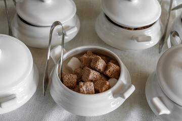 Sugar bowls with tongs filled with fruit sugar.