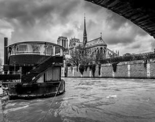 A boat moored in the River Seine with the Notre Dame Cathedral in the background.- Paris France 