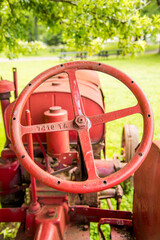 Fototapeta na wymiar A red steering wheel on an old tractor. 