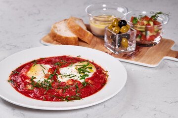 Close-up photo of dish on plate, eggs in red sauce soup beautifully served for restaurant guests. Professionally cooked meal garnish