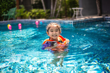 Fototapeta na wymiar An Asian little girl in the pool