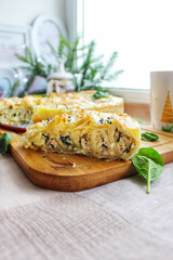 Homemade pastry a cut piece of baked lasagna on a wooden cutting board