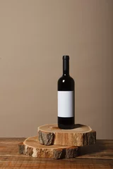 Poster Blank white label mock up on black bottle of unlabeled red wine on a wooden table. Alcohol bottle mockup presentation ready for logo design. Full drink bottle template with empty sticker. © Константин Сапрыкин