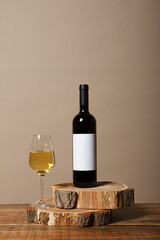 Blank white label mock up on black bottle of unlabeled wine on a wooden table. Alcohol bottle...