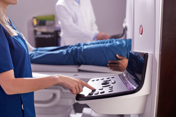 Doctor Assistant Turning On Complete CAT Scan System in Hospital Environment. Magnetic resonance imaging scan. Close-up hands and Equipment