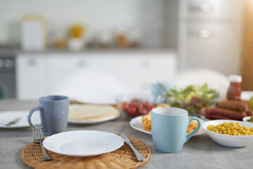 Fototapeta na wymiar Close up of plate and cups with Latin American breakfast on the table in modern kitchen interior